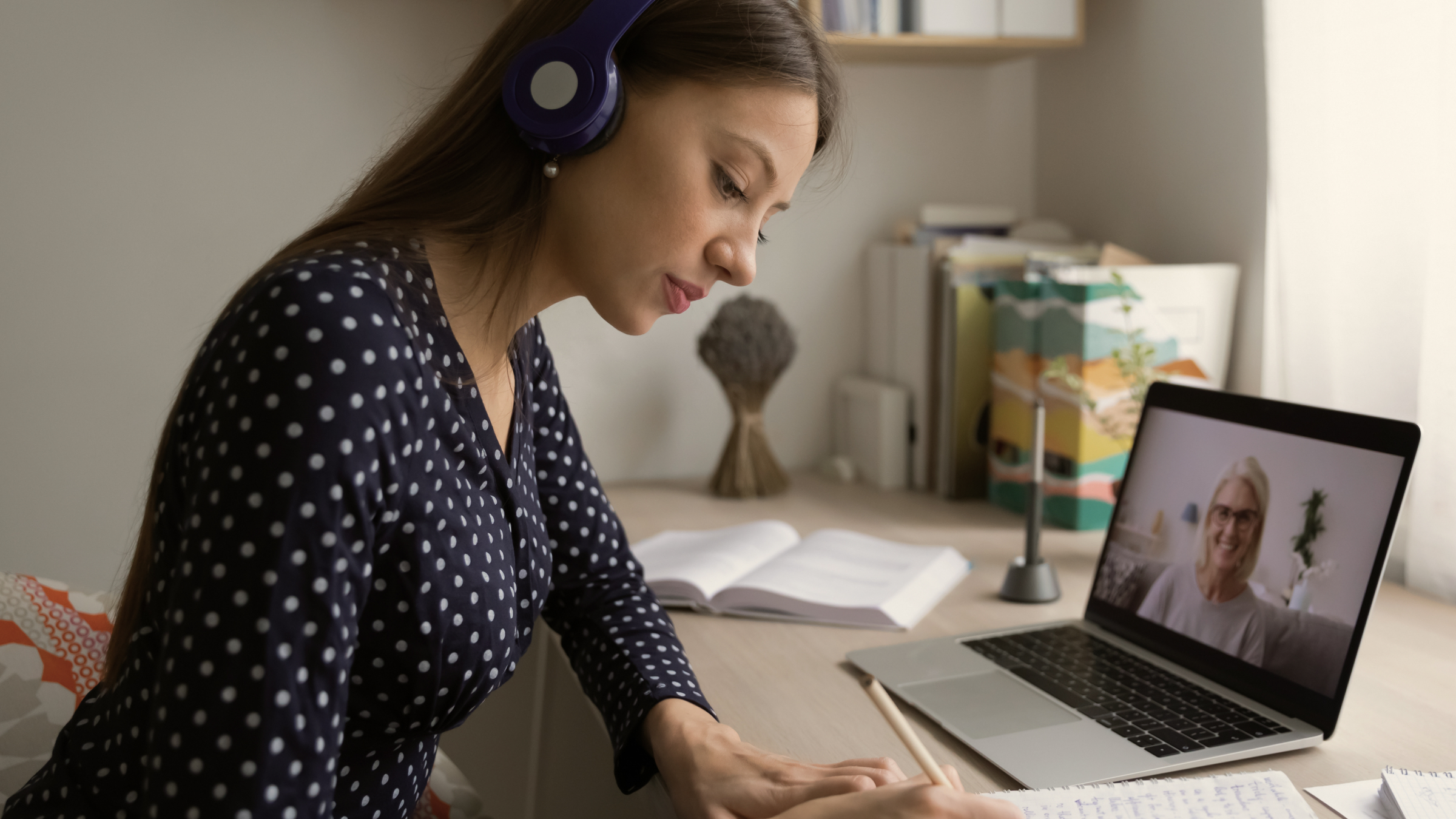 An older adult mentor and a young person talking together during a video call